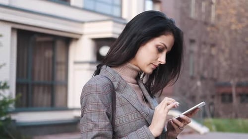 Stylish Woman Using Smartphone in Urban Setting