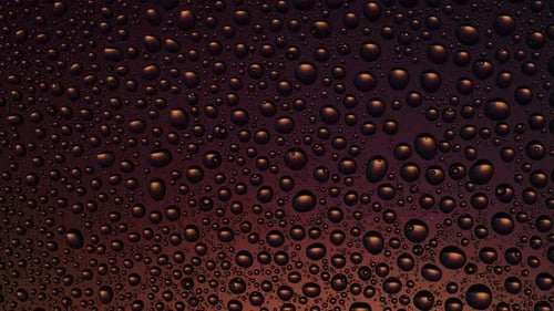 Textur-Wassertropfen auf dem orange-gelben Glashintergrund. Bewegtes Licht, wechselnde Farbe.