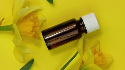 Aromatherapy Bottle with Daffodils on Yellow Background