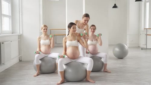 Pregnant Women Exercising With an Instructor in Studio