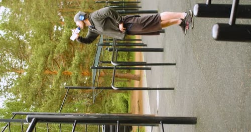 Man Drinking Water at Outdoor Gym in Park