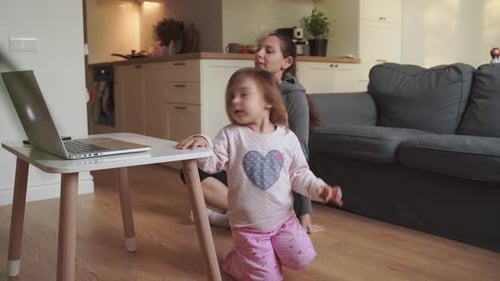 Woman and Child Exercising on Floor at Home