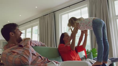 Happy Family Playing Together Indoors on Couch