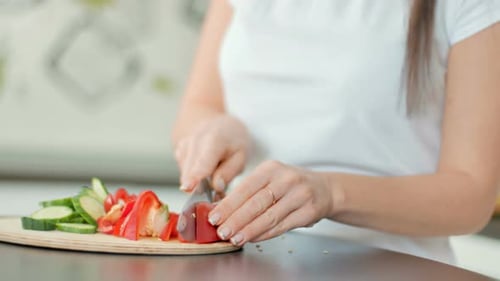 Woman Slicing Red Pepper for Salad Preparation