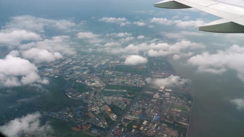 Aerial View of City From Airplane Window on Cloudy Day