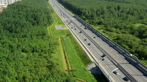 Asphaltspeedway mit Autos durch die grüne Wiese. Luftaufnahme von der Drohne