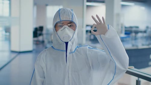 Person in Protective Suit Making OK Hand Gesture