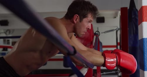 Boxer Resting on Ropes After Workout