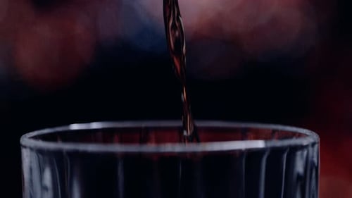 Dark Liquid Pours into Glass Close Up