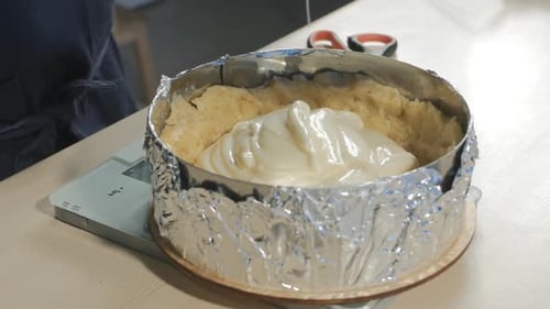 el chef pone la masa y las natillas en un molde