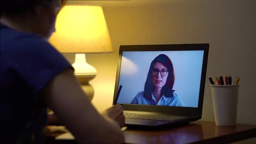 Woman Video Chatting with Student on Laptop at Night