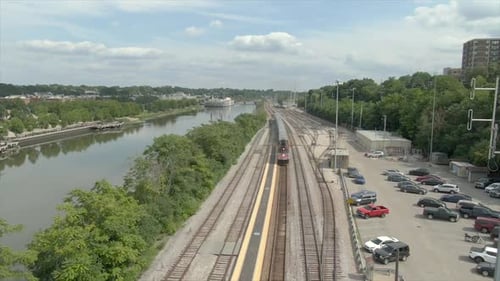Train Pulling into Station beside City River