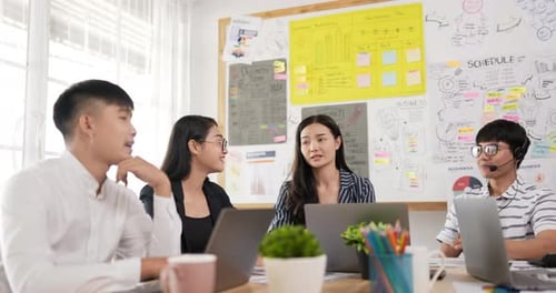 Enthusiastic Team High-Fiving During Meeting at Office