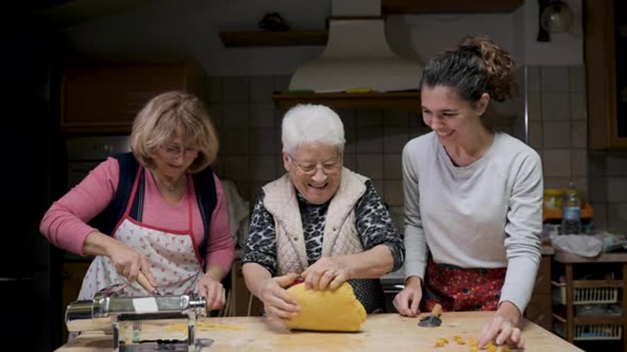 Cover for Cheerful women cooking tortellini in kitchen together