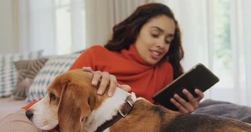 Woman Relaxes Indoors with Dog and Tablet