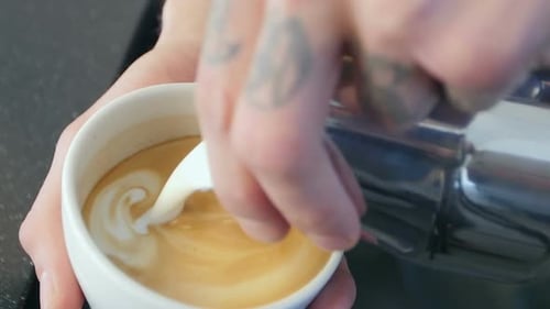 Barista Pouring Steamed Milk Into Coffee Latte Art
