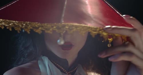 Glamorous Woman in Ornate Hat with Bold Makeup
