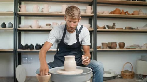 Man Shaping Clay on Pottery Wheel in Workshop