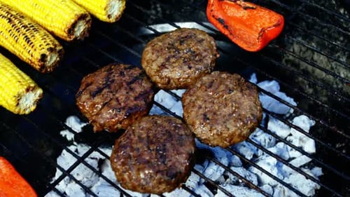 Burger Patties and Vegetables Grilling on Charcoal BBQ