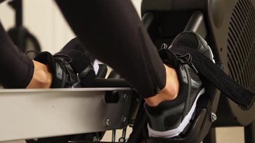 Legs Exercising on Rowing Machine in Gym