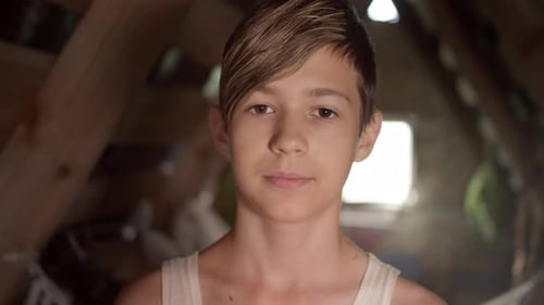 Portrait of a Happy Boy Looking at the Camera and Smiling Attic House Near the Window Abandoned