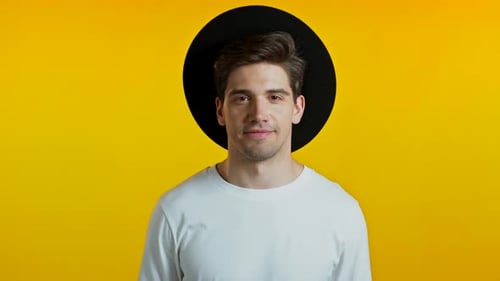 Handsome European Man with Trendy Hairdo in Hat on Yellow Studio Background, Cheerful Guy Smiling