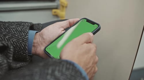 Un hombre usa un smartphone en el autobús. Pantalla verde. Maqueta de teléfono.