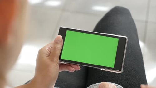 Display of mobile phone with green screen in blond female hands 4K 2160p 30fps UltraHD footage - Bl