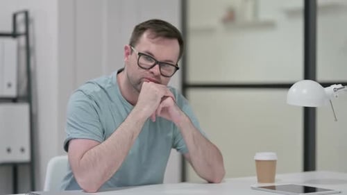 Pensive Young Man Thinking at Work
