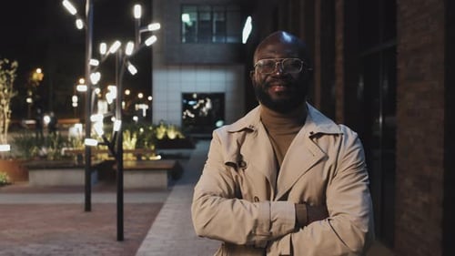 Man in Trench Coat Standing at Night in City