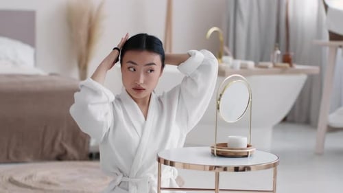 Elegant Woman Putting Hair in Ponytail at Home