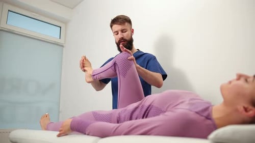 Man Helping Woman with Leg Stretching in Office