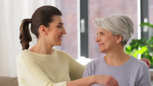 Woman Embraces her Smiling Mother Indoors