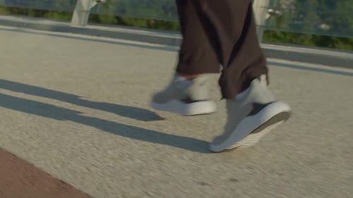 Rear View of Male Athlete in Sports Shoes Running on City Street at Daybreak