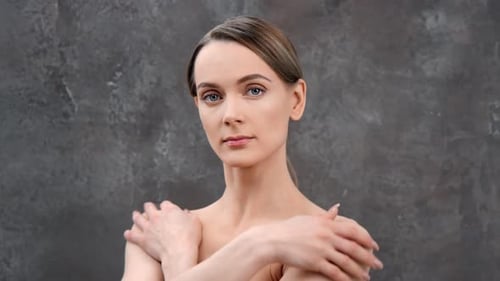 Elegant Woman Posing Against Grey Wall