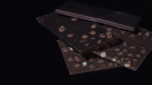 Dark Chocolate Blocks with Nuts Details Slow Close-up Macro. Chocolate Bars