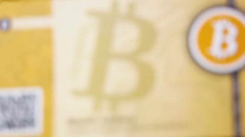 Un billet de banque avec logo Bitcoin tombe sur une pile de pièces