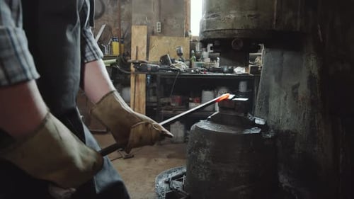 Blacksmith Using Heavy Industrial Machine in Workshop