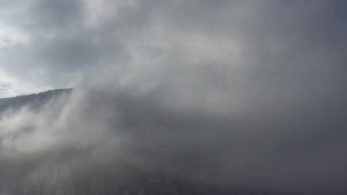 Strong mist and clouds over the mountain top 4K aerial video