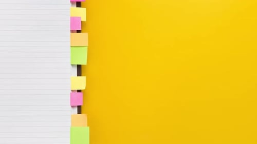 Colorful Sticky Notes on Open Notebook with Yellow Background