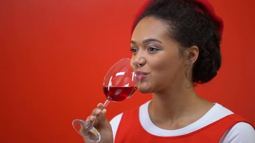 Fröhliche Frau trinkt Rotwein genießt Geschmack und Aroma, Sommelier-Beruf