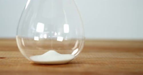 Sand pouring in glass jar