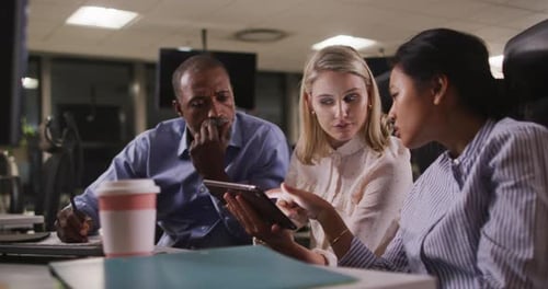 Professional business people discussing over a digital tablet in modern office in slow motion