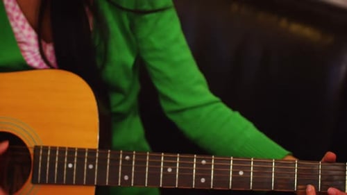 Young Adult Plays Acoustic Guitar Indoors