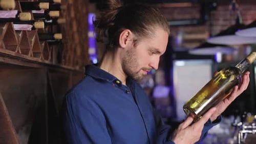 Man Holding Bottle of Wine in Restaurant