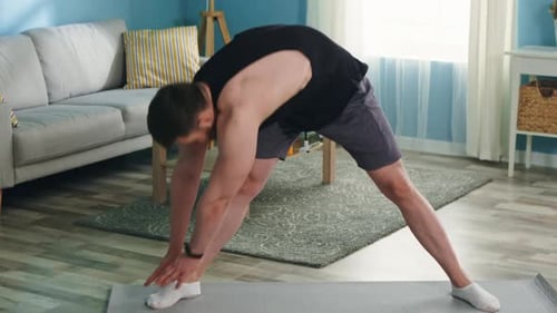 Man Stretching on Yoga Mat in Living Room