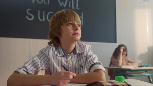 Thoughtful Student Sitting at School Desk Classroom