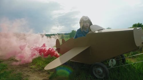 Father and Son Playing with Cardboard Airplane at the Daytime