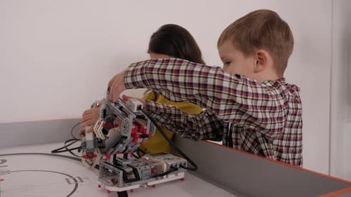 Nahaufnahme einer Gruppe von Kindern, die mit Robotern spielen, die aus Kunststoffteilen zusammengesetzt sind