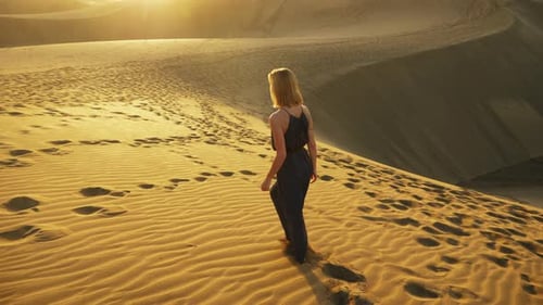 Woman Walking Barefoot on Sand Dunes at Sunset